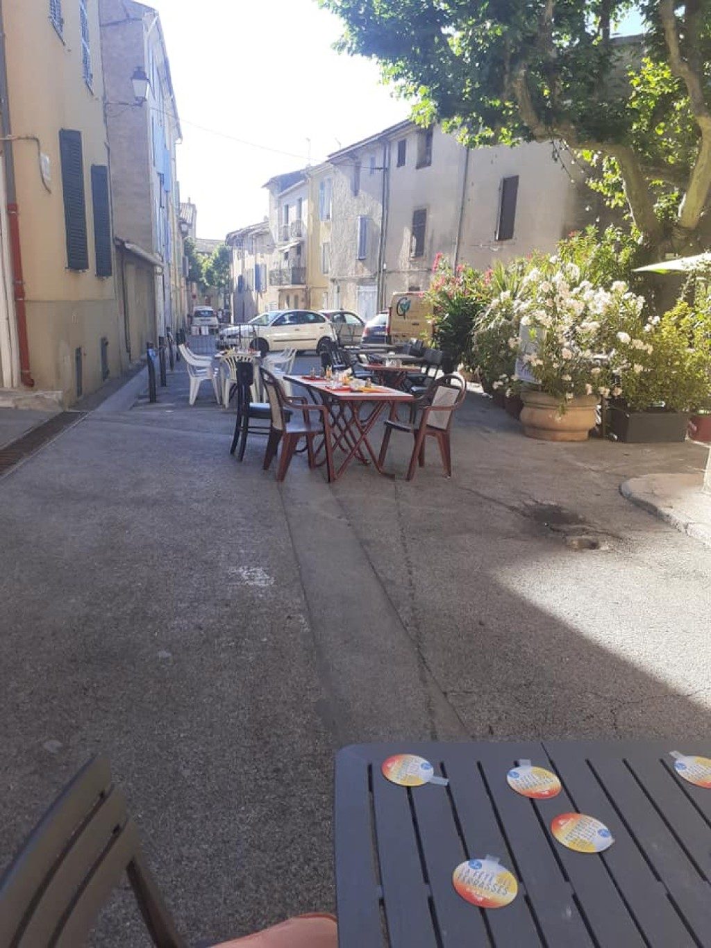 La ruelle ombragée du centre-ville et ses tables de terrasse